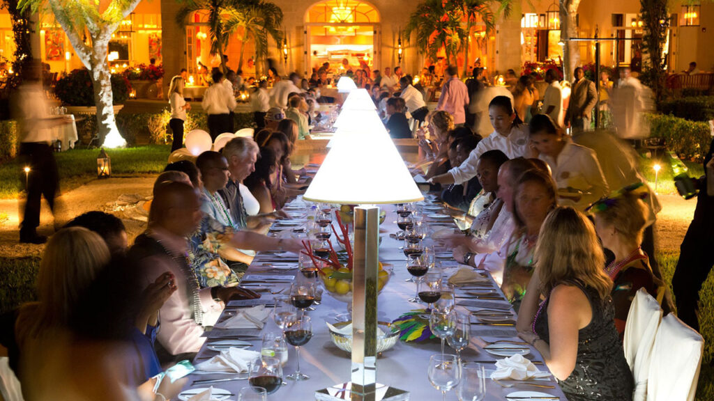 Caribbean Food & Wine Festival Guests Seated at a Long Table With Wine